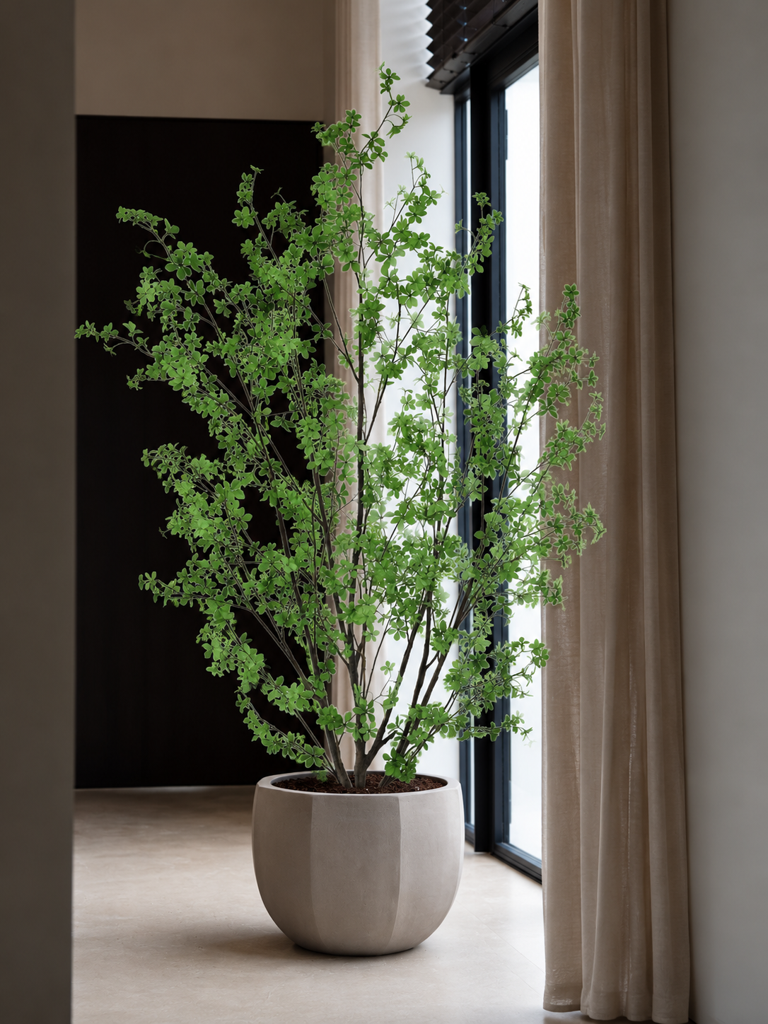 Kunstboom in een lichte pot bij een raam