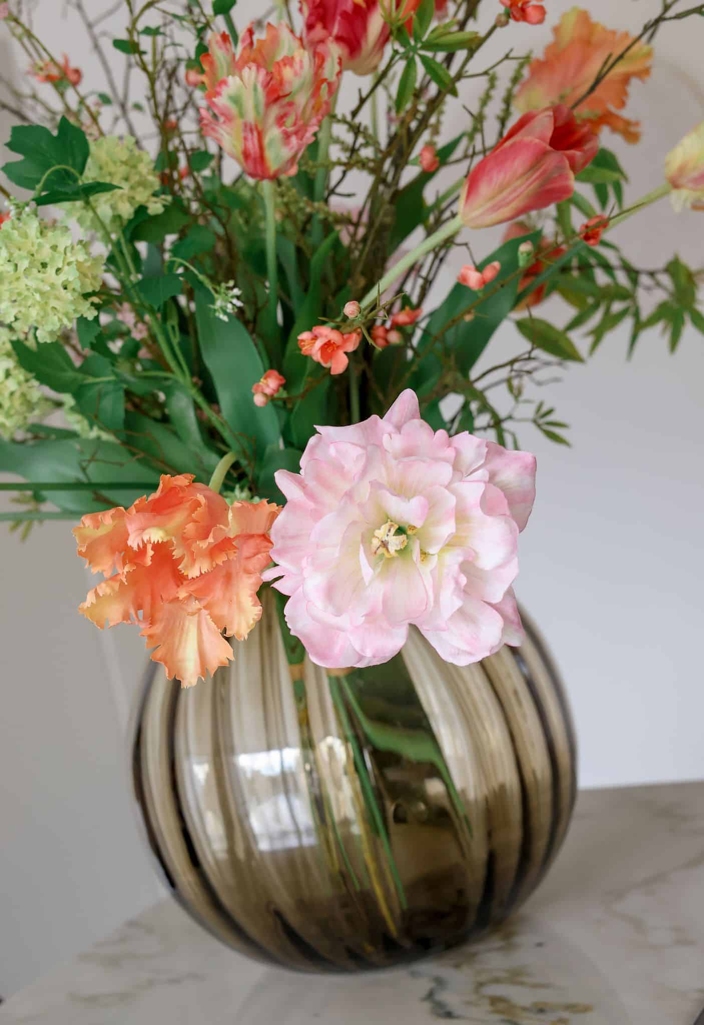 Luxe zijden bloemen: boeket met roze pioenen in een glazen vaas