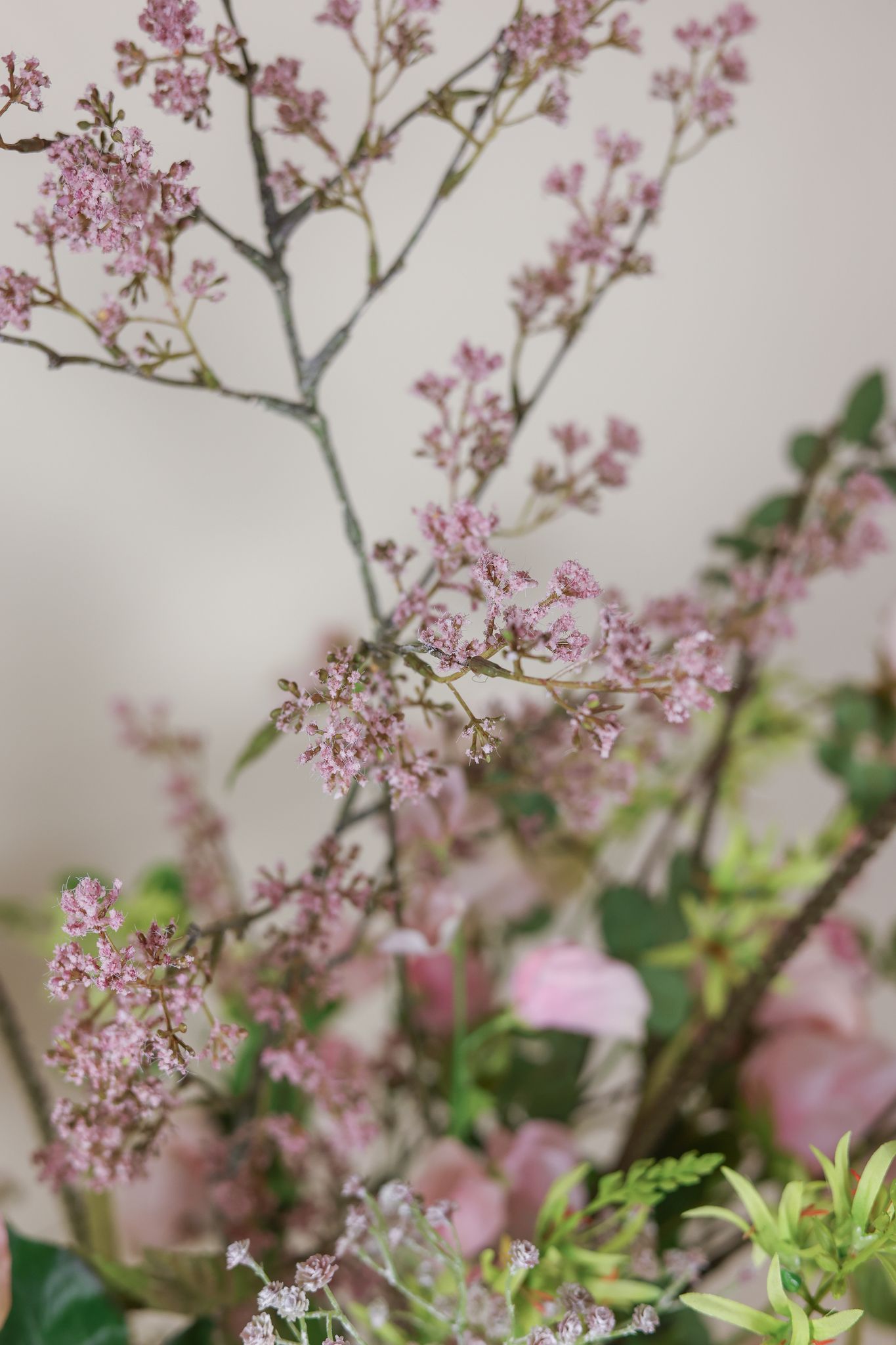 Detail van roze bloesemtakken in een zijden bloemstuk
