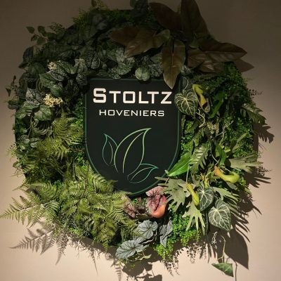 Rond mospaneel van kunstplanten met bedrijfslogo