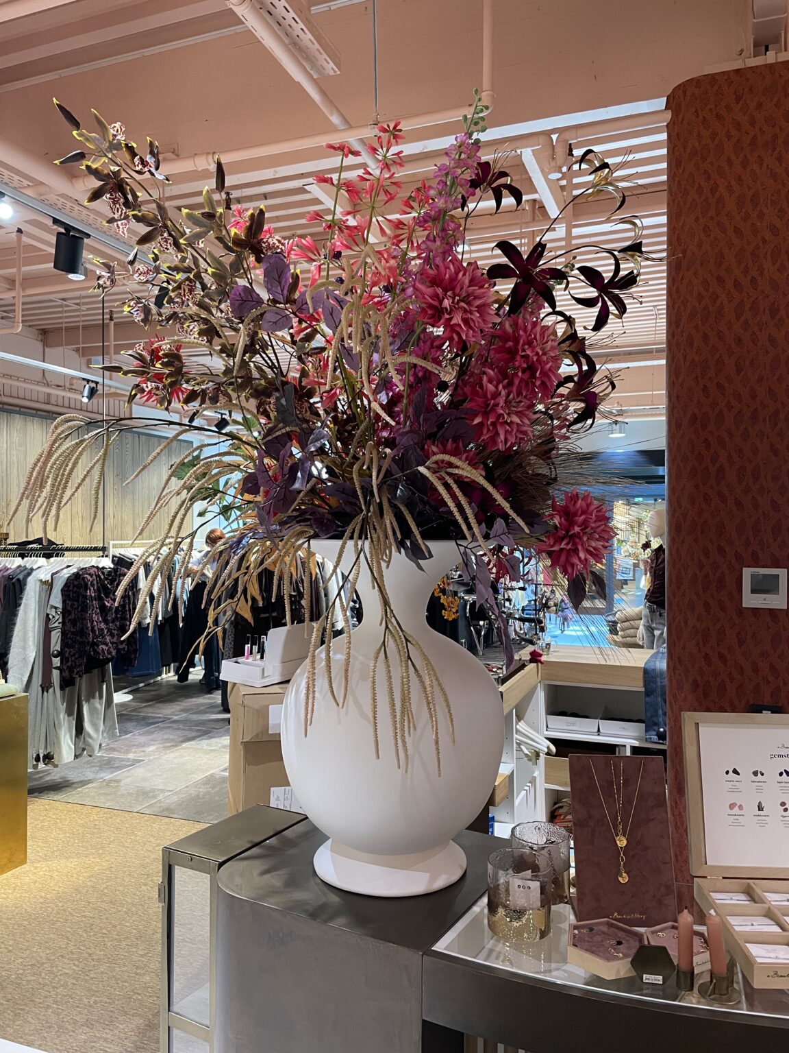Zakelijk kunstbloemen abonnement: zijden bloemstuk in een witte vaas in een winkel