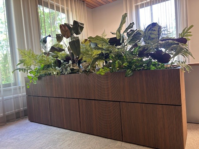 Zakelijke interieurbeplanting op kantoor: houten plantenbak als roomdivider met kunstplanten